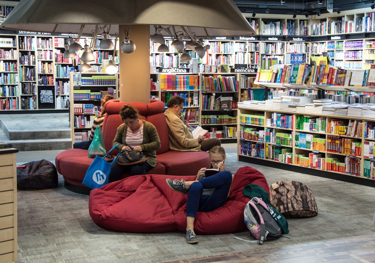about-us A welcoming library space with people relaxing and reading on comfortable seating.