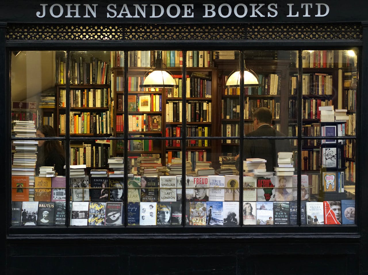 A cozy London bookstore showcasing various books through a classic window display.