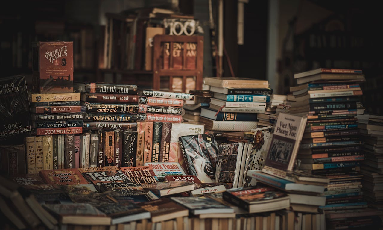 who-we-are A cozy indoor bookstore with stacked bookshelves filled with novels and literature.